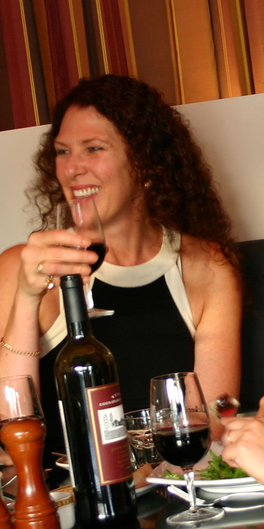 Woman in a restaurant enjoying a glass of red wine.